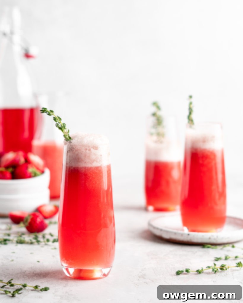 Bright red strawberry guava juice is mixed with sparkling rose wine in stemless champagne glasses to make Strawberry Guava Mimosa
