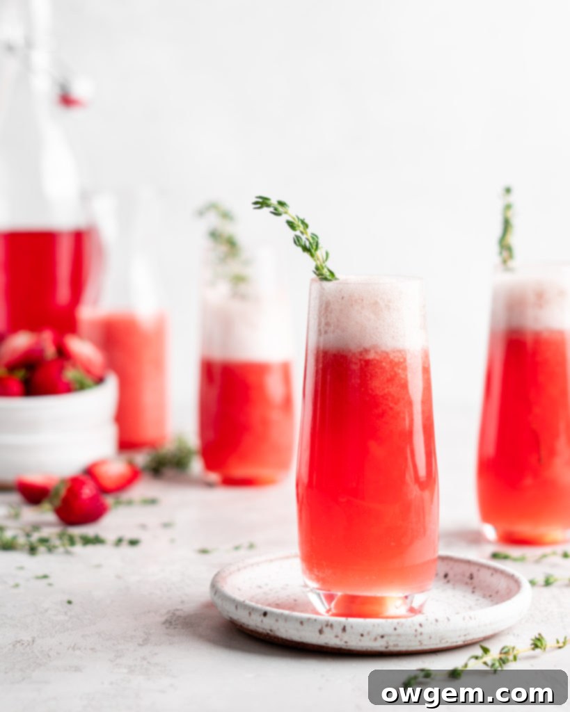 Bright red strawberry guava juice is mixed with sparkling rose wine in stemless champagne glasses to make Strawberry Guava Mimosa