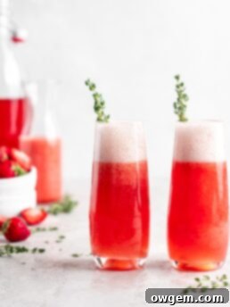 Bright red strawberry guava juice is mixed with sparkling rose wine in stemless champagne glasses to make Strawberry Guava Mimosa