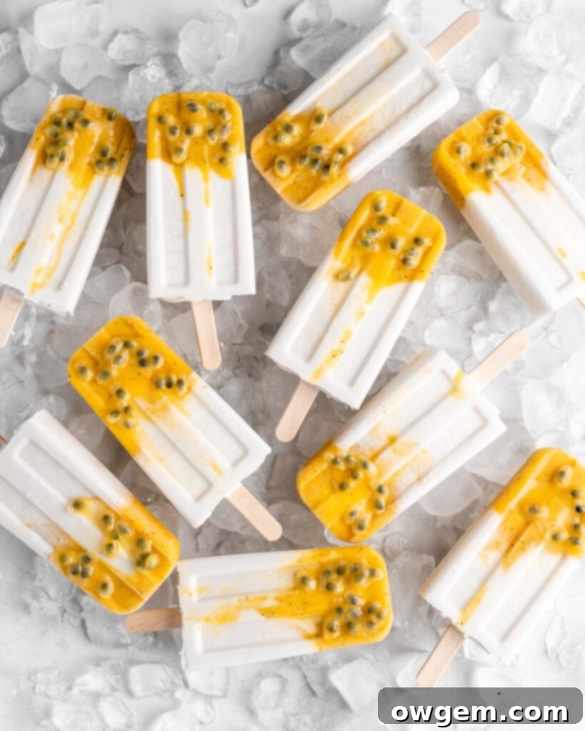 Tropical popsicles featuring mango, passion fruit, and coconut lay on a bed of ice