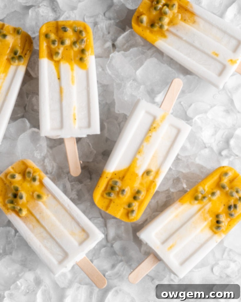 Tropical popsicles featuring mango, passion fruit, and coconut lay on a bed of ice