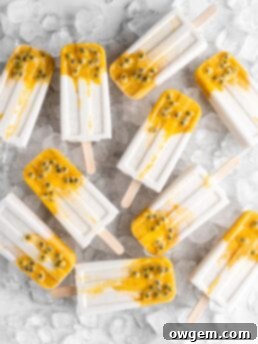Tropical popsicles featuring mango, passion fruit, and coconut lay on a bed of ice