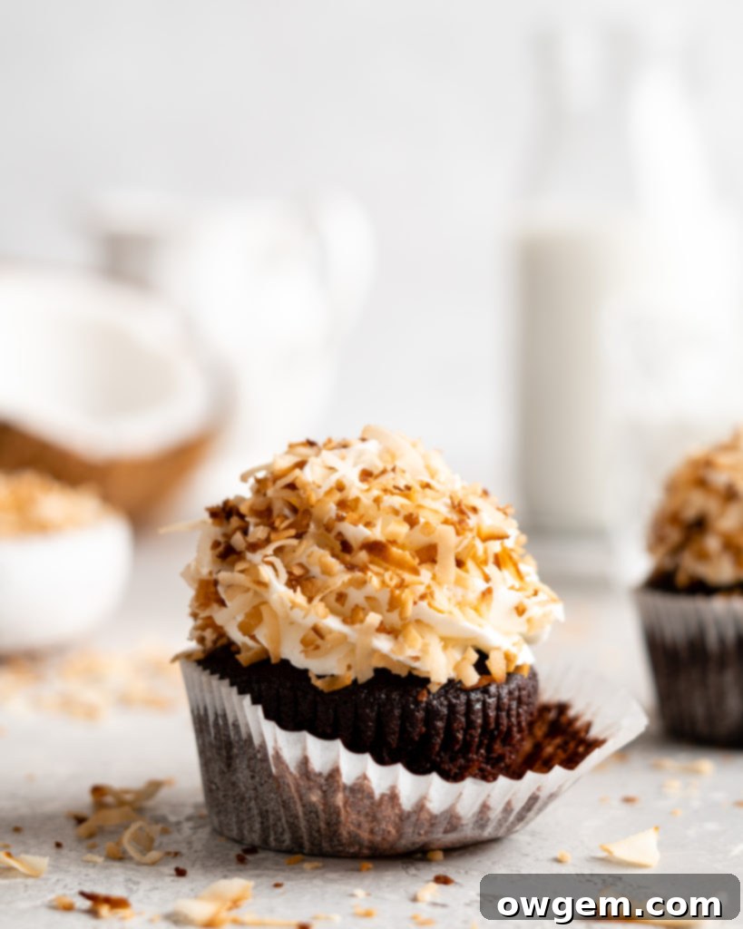Stacked chocolate coconut cupcakes with creamy frosting and toasted coconut