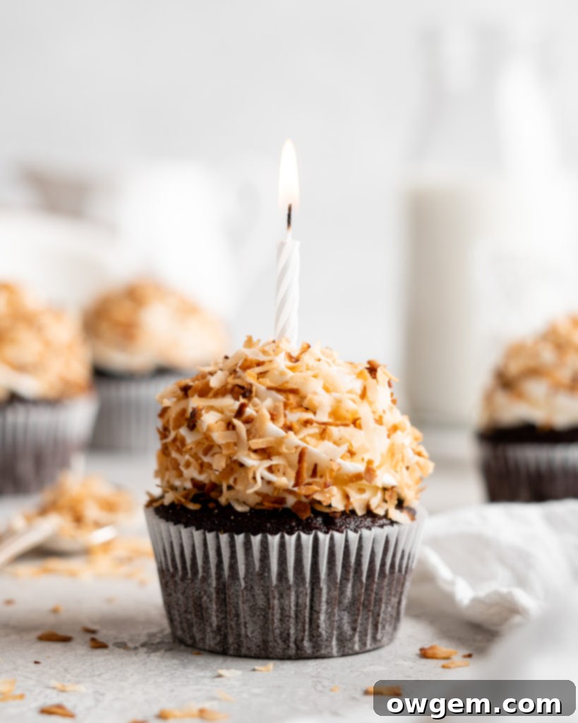 A chocolate coconut cupcake being frosted with creamy white coconut buttercream