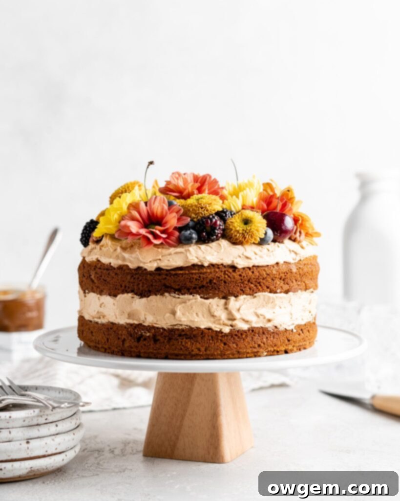 Two thick brown butter pumpkin cake layers are sandwiched together with a generous amount of dulce de leche Russian buttercream, showcasing a decadent fall dessert.
