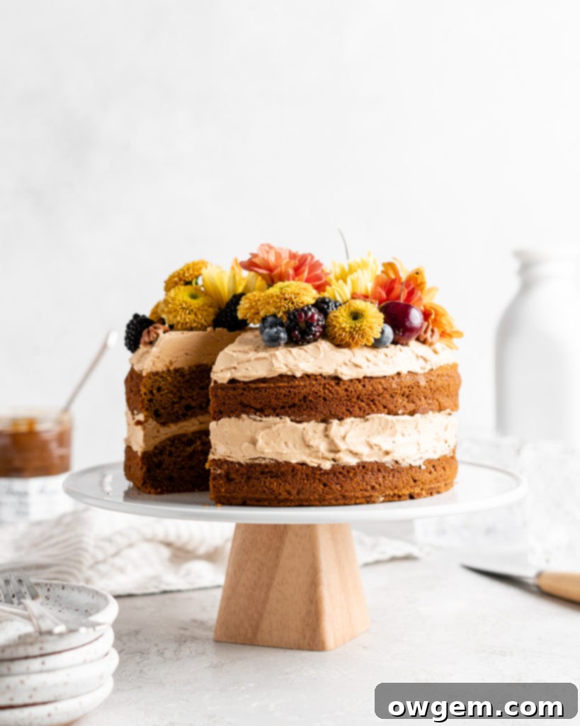 A beautifully frosted brown butter pumpkin cake with dulce de leche Russian buttercream, adorned with a few edible flowers.