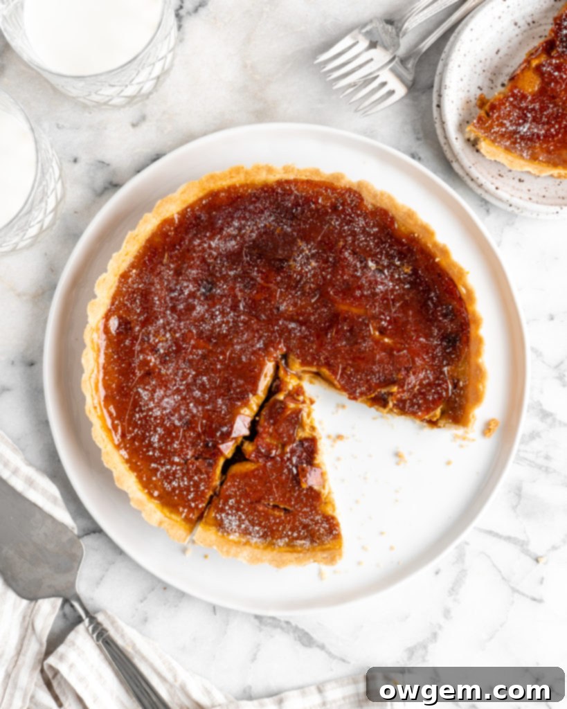 Velvety pumpkin tart is topped with a creme brulee topping and baked in a buttery shortbread crust