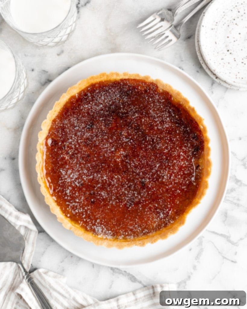Velvety pumpkin tart is topped with a creme brulee topping and baked in a buttery shortbread crust