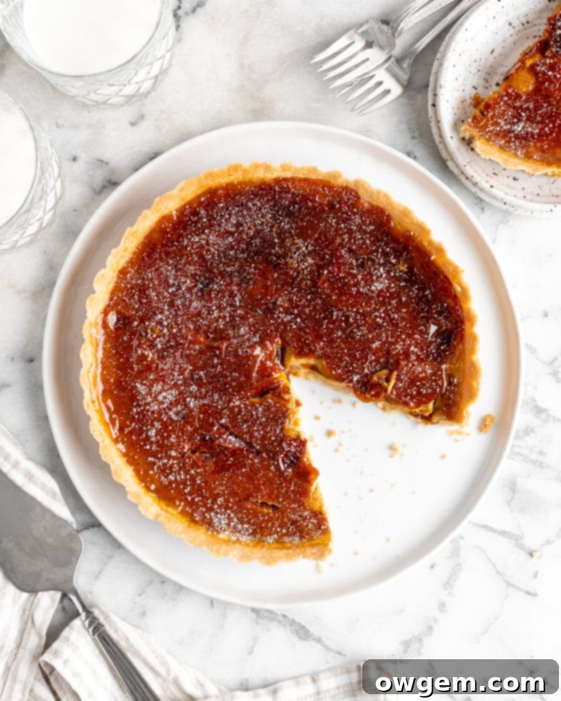 Velvety pumpkin tart is topped with a creme brulee topping and baked in a buttery shortbread crust