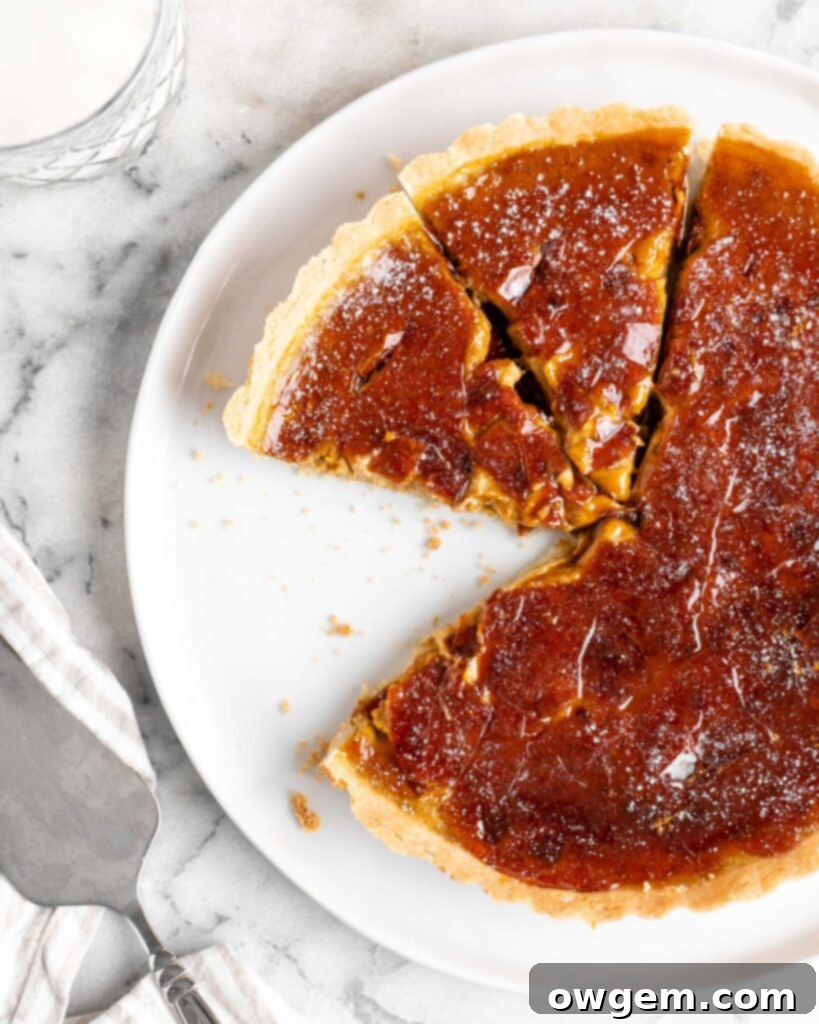 Velvety pumpkin tart is topped with a creme brulee topping and baked in a buttery shortbread crust