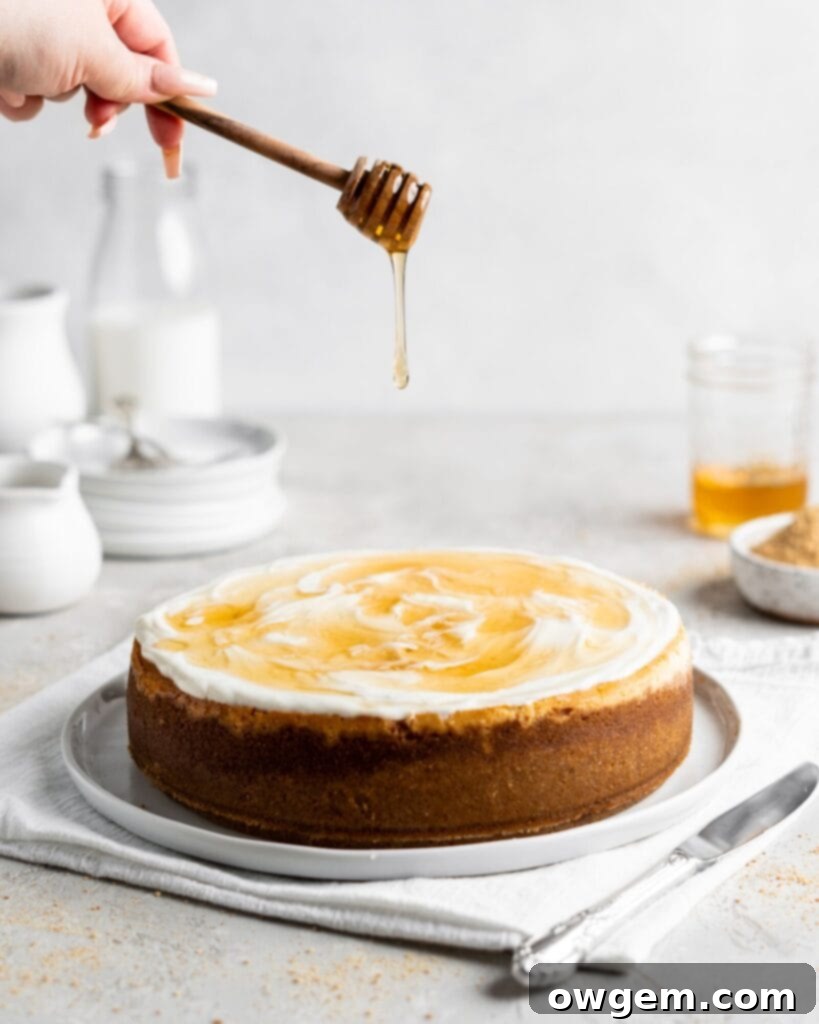 Creamy Salted Honey Cheesecake has a graham cracker crust and a sour cream topping. Drizzled with additional salted honey