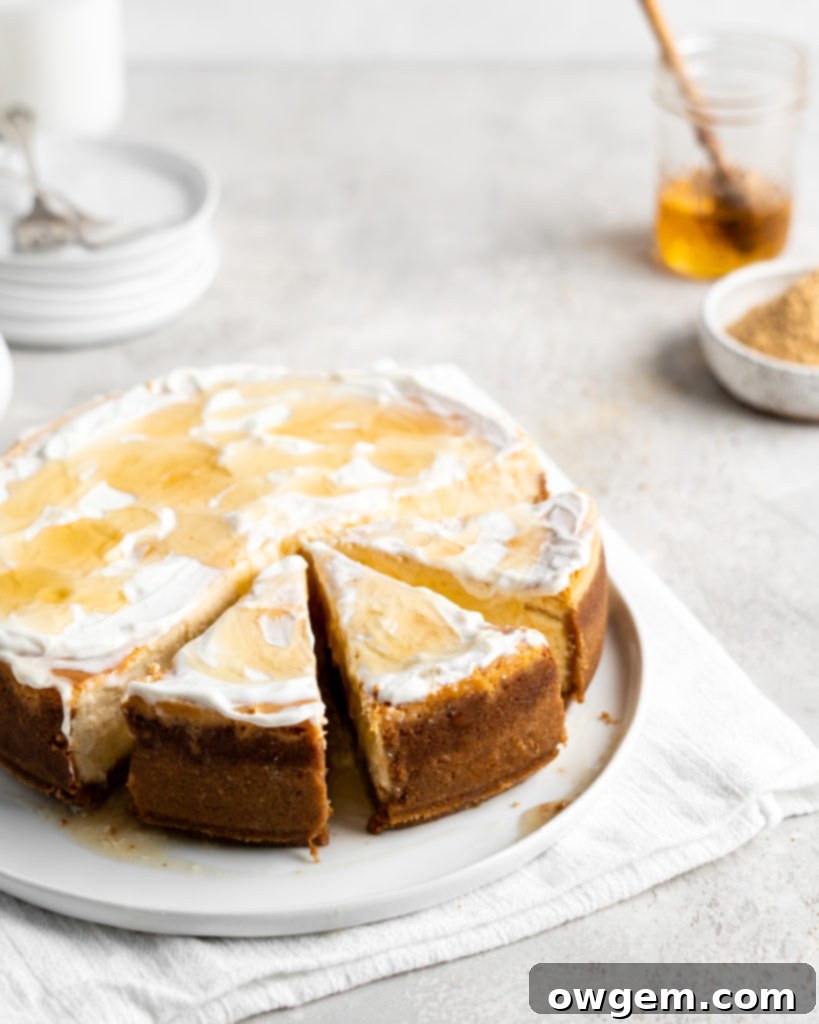 Creamy Salted Honey Cheesecake has a graham cracker crust and a sour cream topping. Drizzled with additional salted honey