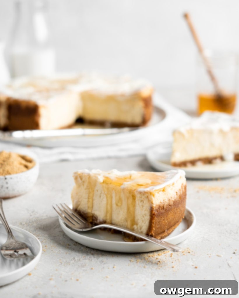 Creamy Salted Honey Cheesecake has a graham cracker crust and a sour cream topping. Drizzled with additional salted honey