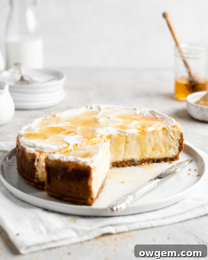 Creamy Salted Honey Cheesecake has a graham cracker crust and a sour cream topping. Drizzled with additional salted honey