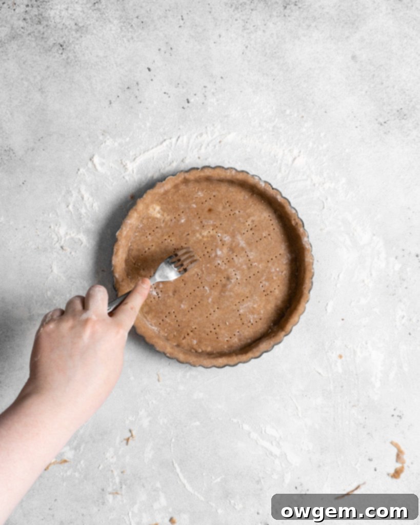 Blind baking the chai-spiced tart crust with pie weights.