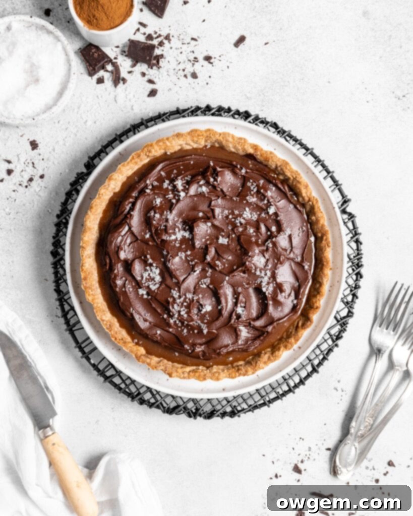 This Chai Salted Caramel Chocolate Tart features a spicy chai infused crust, chai salted caramel filling, and a creamy chocolate ganache topping