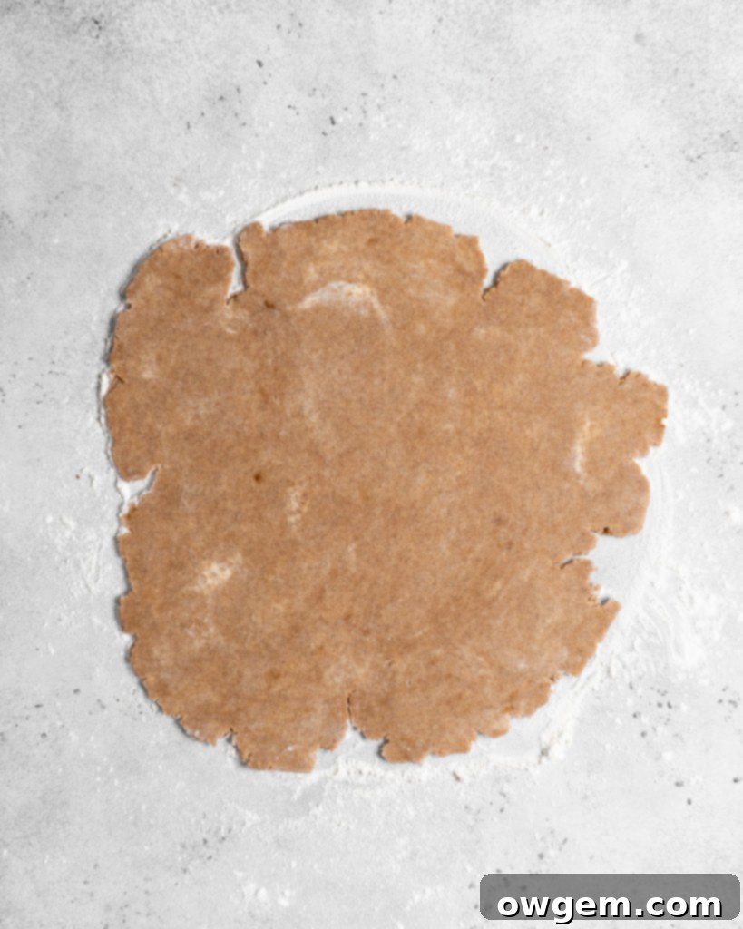 Folding the delicate chai shortcrust pastry onto the tart pan bottom before transfer.