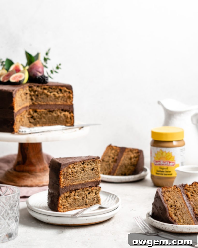 An inviting slice of a two-layer SunButter Banana Cake, showcasing its perfectly layered structure and generous chocolate frosting.