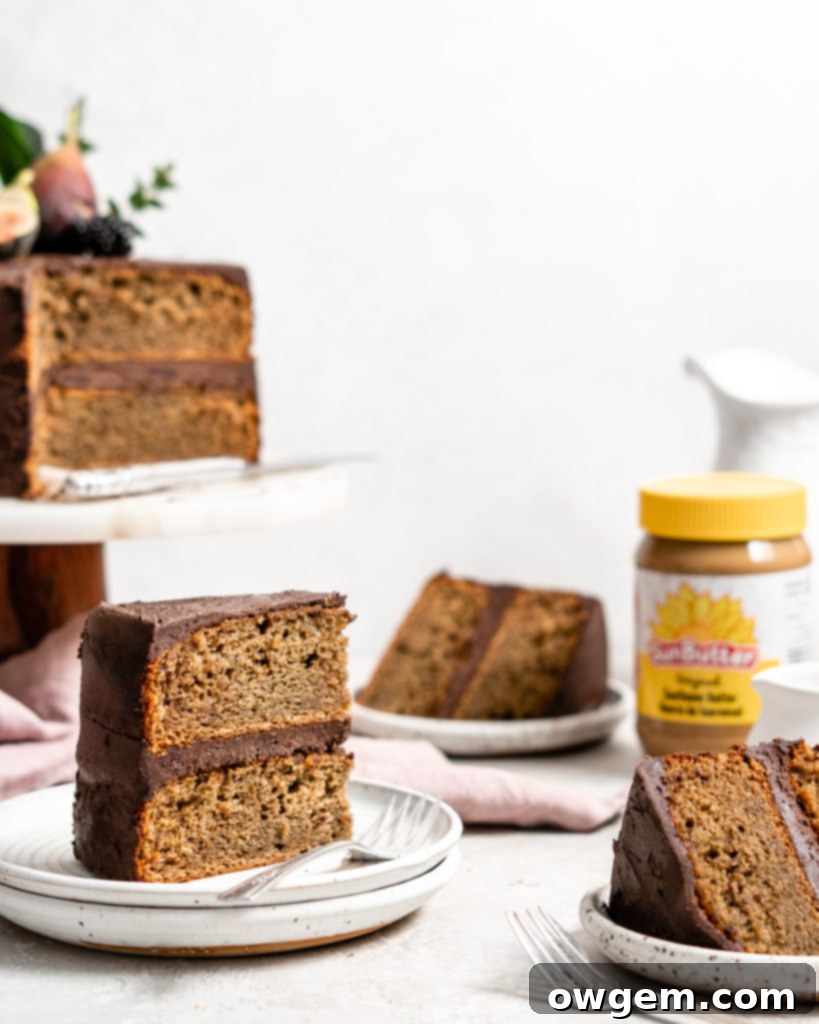 A delectable slice of a two-layer SunButter Banana Cake, lavishly covered with rich chocolate frosting, promising a delightful treat.
