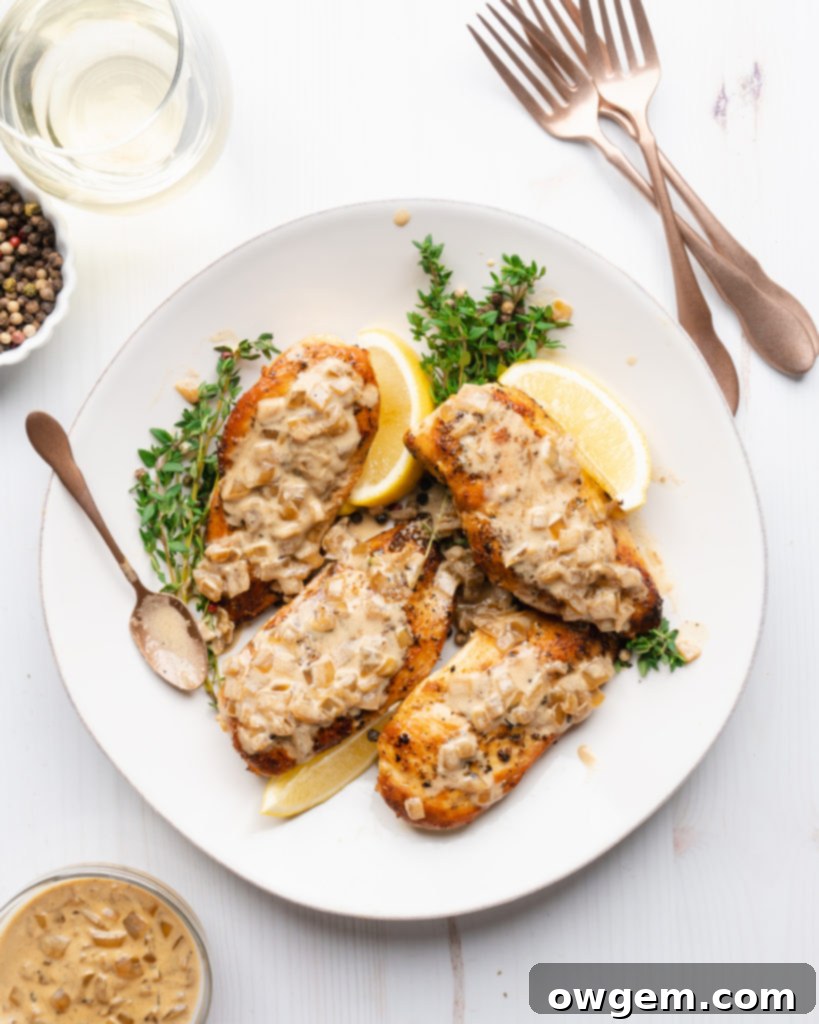 Chicken breasts on a plate, topped with white wine cream sauce