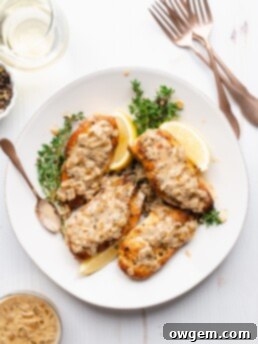 Chicken breasts on a plate, topped with white wine cream sauce