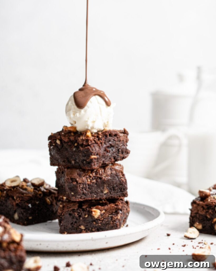 Close-up of fudgy toasted hazelnut brownies swirled with Nutella, showcasing rich chocolate and nutty texture