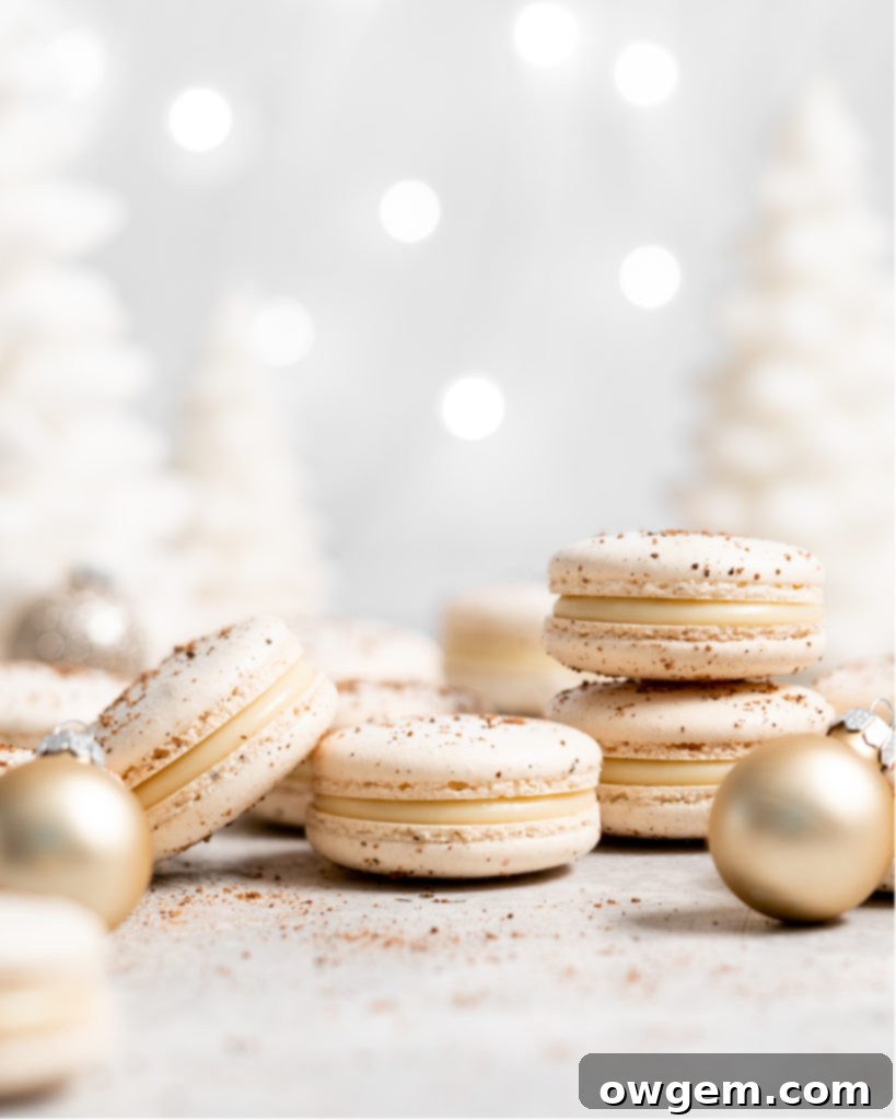 Close-up of baked eggnog macarons, perfectly formed with 'feet' and a smooth top, ready for filling.