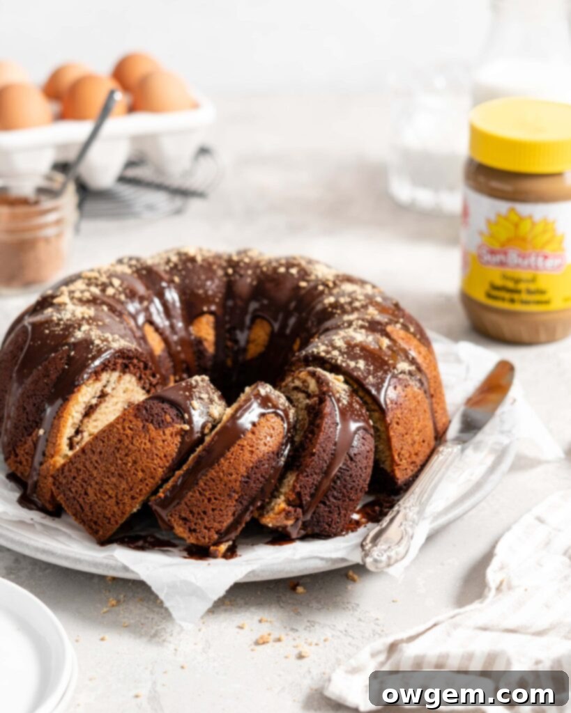 Beautiful SunButter and chocolate marble bundt cake topped with a generous pour of chocolate ganache