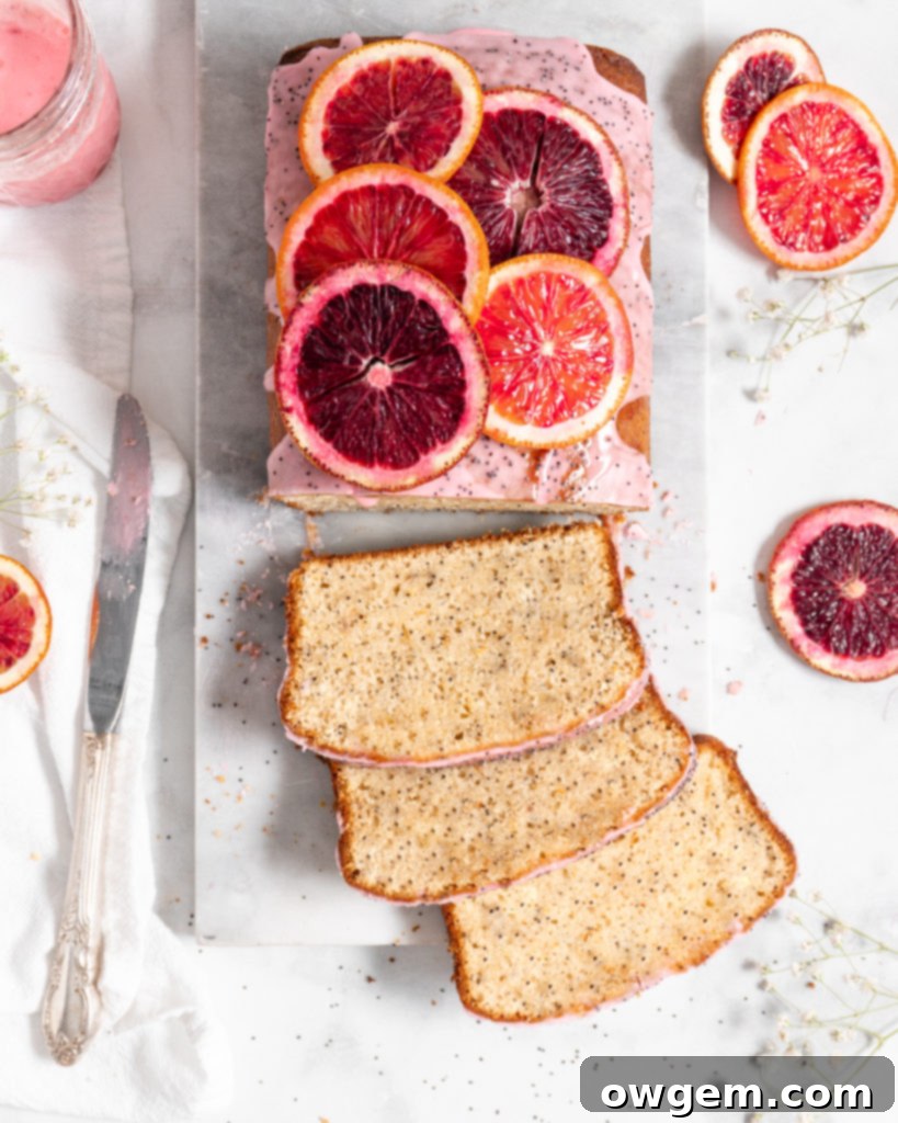 Close-up of blood oranges, some whole and some sliced, showing their distinctive deep red flesh, ready for baking.