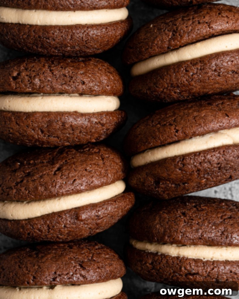 Unfilled chocolate whoopie pie halves arranged on a baking sheet, ready for assembly.
