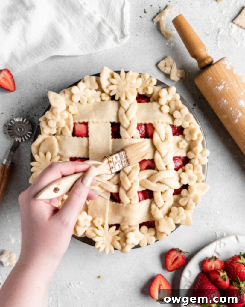 Homemade strawberry pie, freshly baked, cooling on a wire rack, with visible flaky crust and thick filling.
