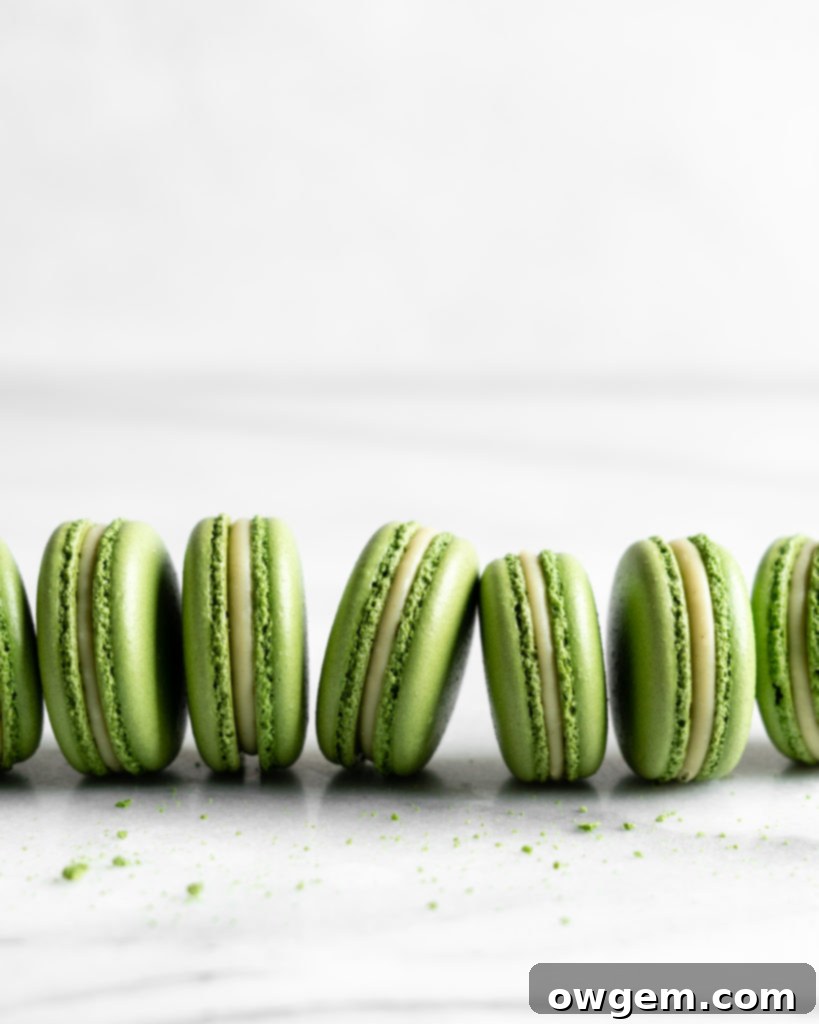 Matcha macaron shells cooling on a baking mat