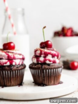 Black forest cupcake with cherry pie filling and whipped cream topping with cherry on top