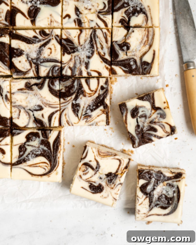 Chocolate SunButter Cheesecake bars stacked on a serving plate, displaying their rich texture