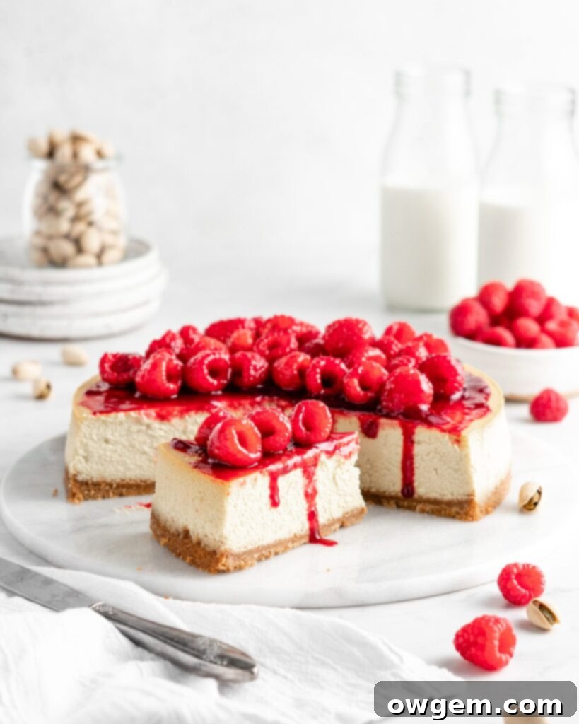 Creamy and rich pistachio cheesecake topped with raspberry sauce and fresh juicy raspberries