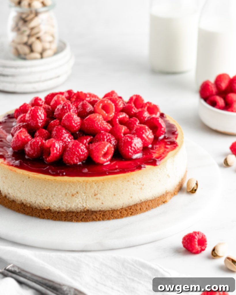 Creamy and rich pistachio cheesecake topped with raspberry sauce and fresh juicy raspberries