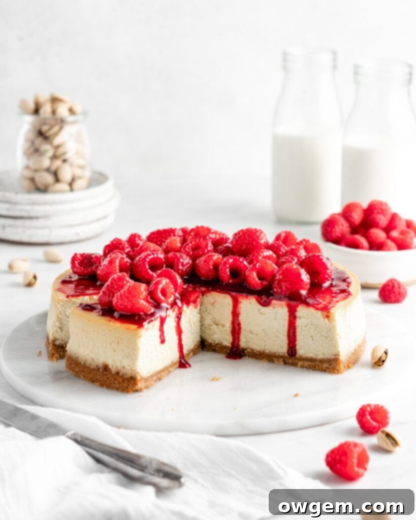 Creamy and rich pistachio cheesecake topped with raspberry sauce and fresh juicy raspberries