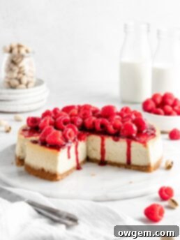 Creamy and rich pistachio cheesecake topped with raspberry sauce and fresh juicy raspberries