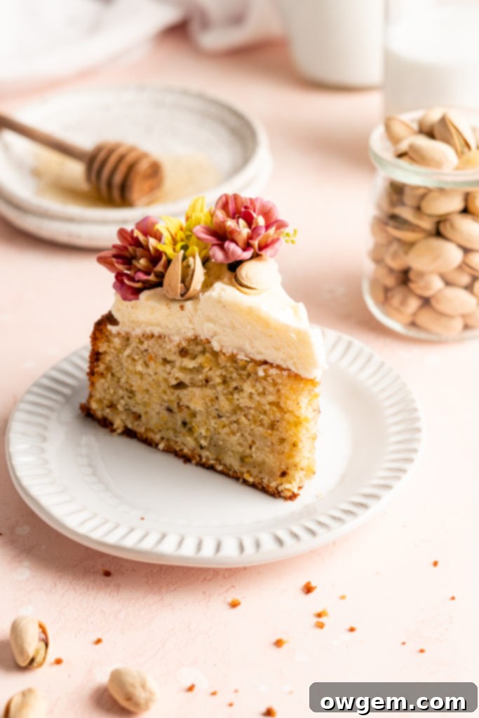 Single layer pistachio cake is topped with creamy honey buttercream and a ton of fresh fruit and flowers