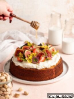 Single layer pistachio cake is topped with creamy honey buttercream and a ton of fresh fruit and flowers