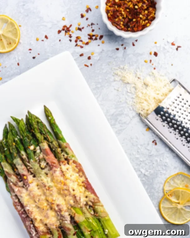 Crispy prosciutto wrapped around fresh green asparagus, plated and topped with parmesan