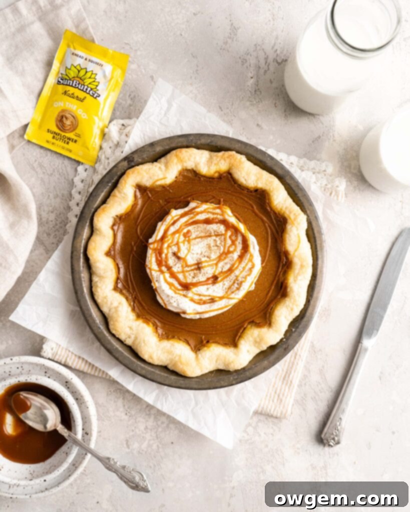 A slice of SunButter Salted Caramel Pumpkin Pie with whipped cream and caramel drizzle