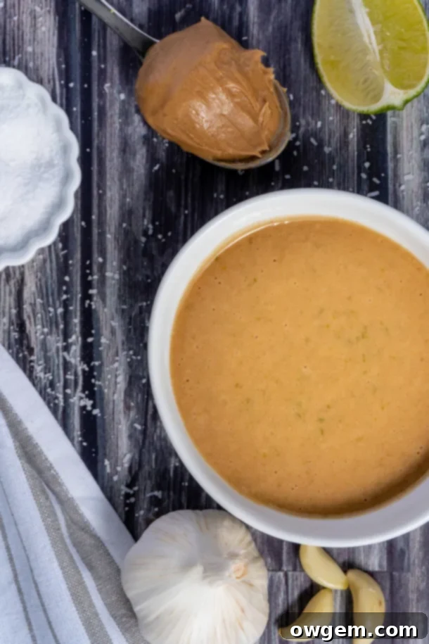 Key ingredients for the homemade peanut-lime vinaigrette: creamy peanut butter, vibrant fresh lime juice, fragrant lime zest, minced garlic, a touch of sugar, and savory soy sauce, beautifully arranged to highlight their freshness.