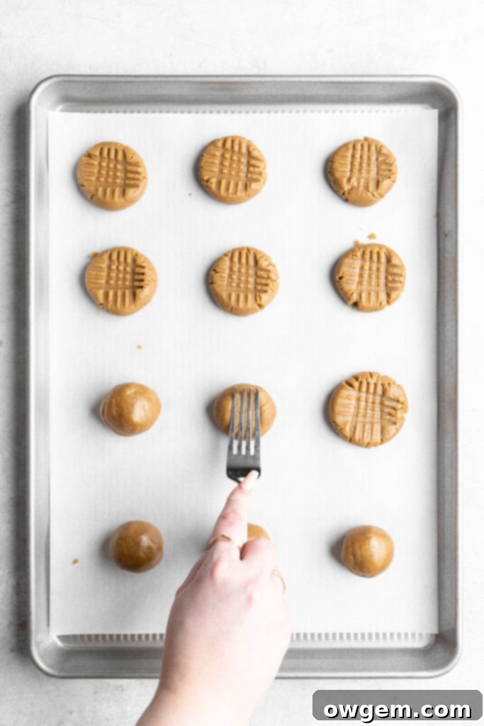 Pressing SunButter cookies into a criss-cross pattern with a fork