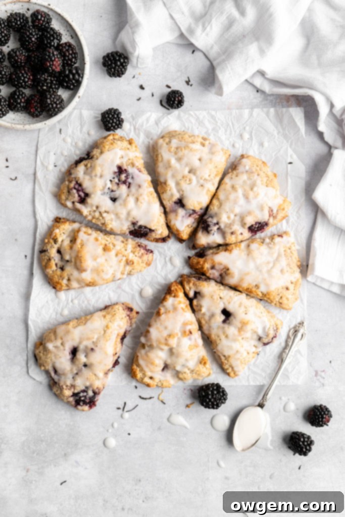 A close-up of a glazed blackberry earl grey scone