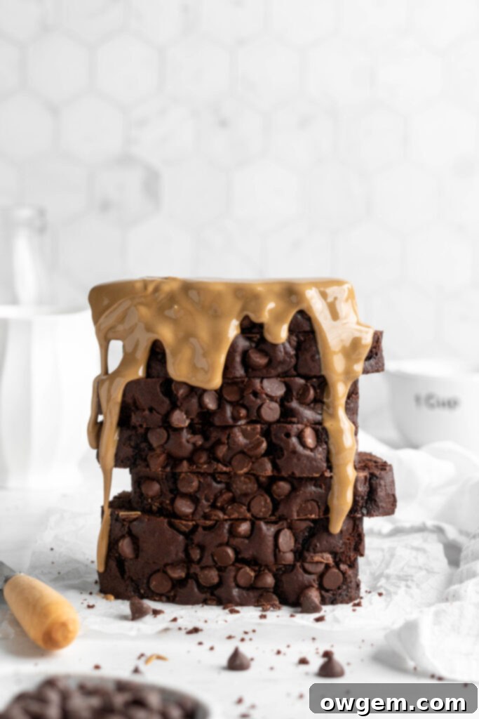 A slice of double chocolate chip loaf cake with melted chocolate chips, indicating a moist and fudgy texture.