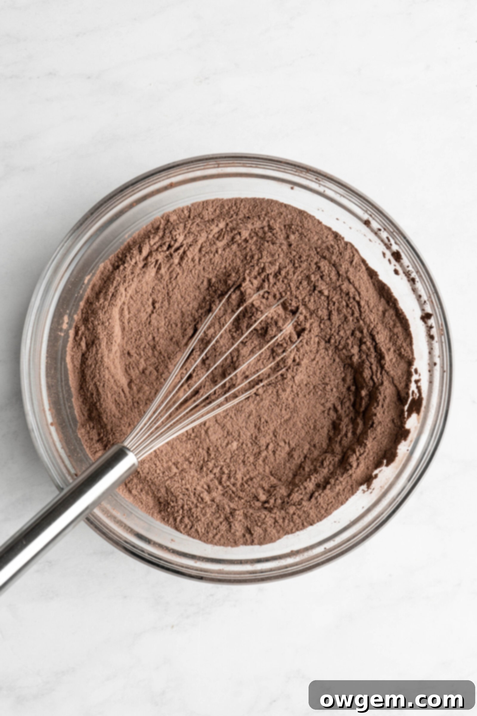 Dry ingredients being whisked together in a separate bowl for a double chocolate chip loaf cake.