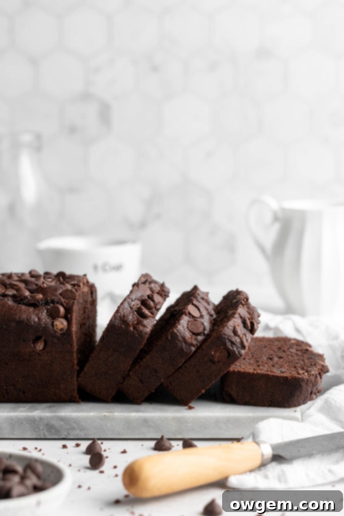 A close-up of a slice of the fudgy SunButter Double Chocolate Chip Loaf Cake, showing its moist crumb and chocolate chips.