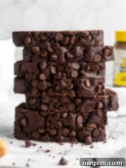 A perfectly baked slice of SunButter Double Chocolate Chip Loaf Cake, rich in chocolate and with a moist crumb.