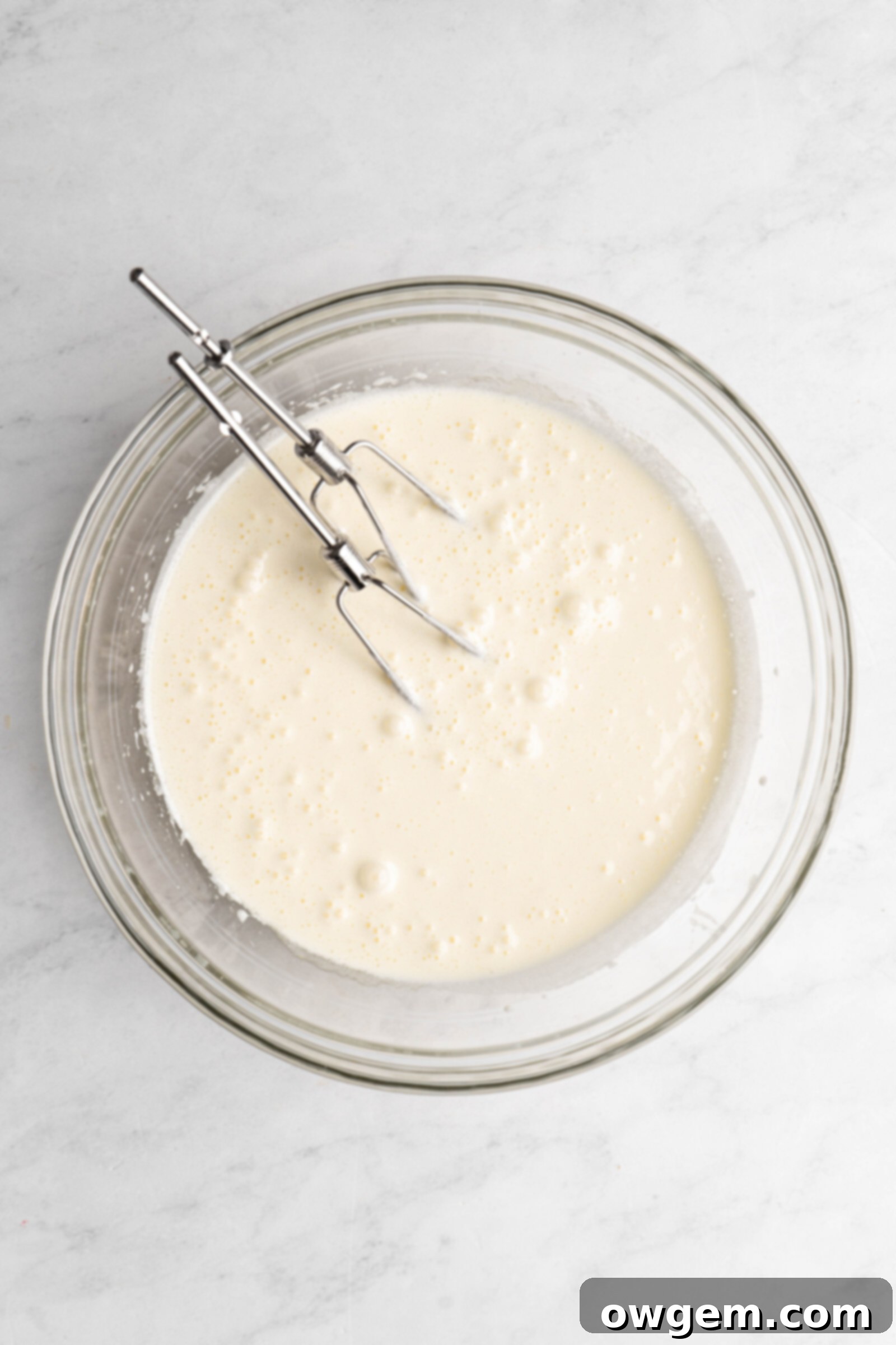 Close-up of whipped sugar and eggs in a mixing bowl for brownie batter.
